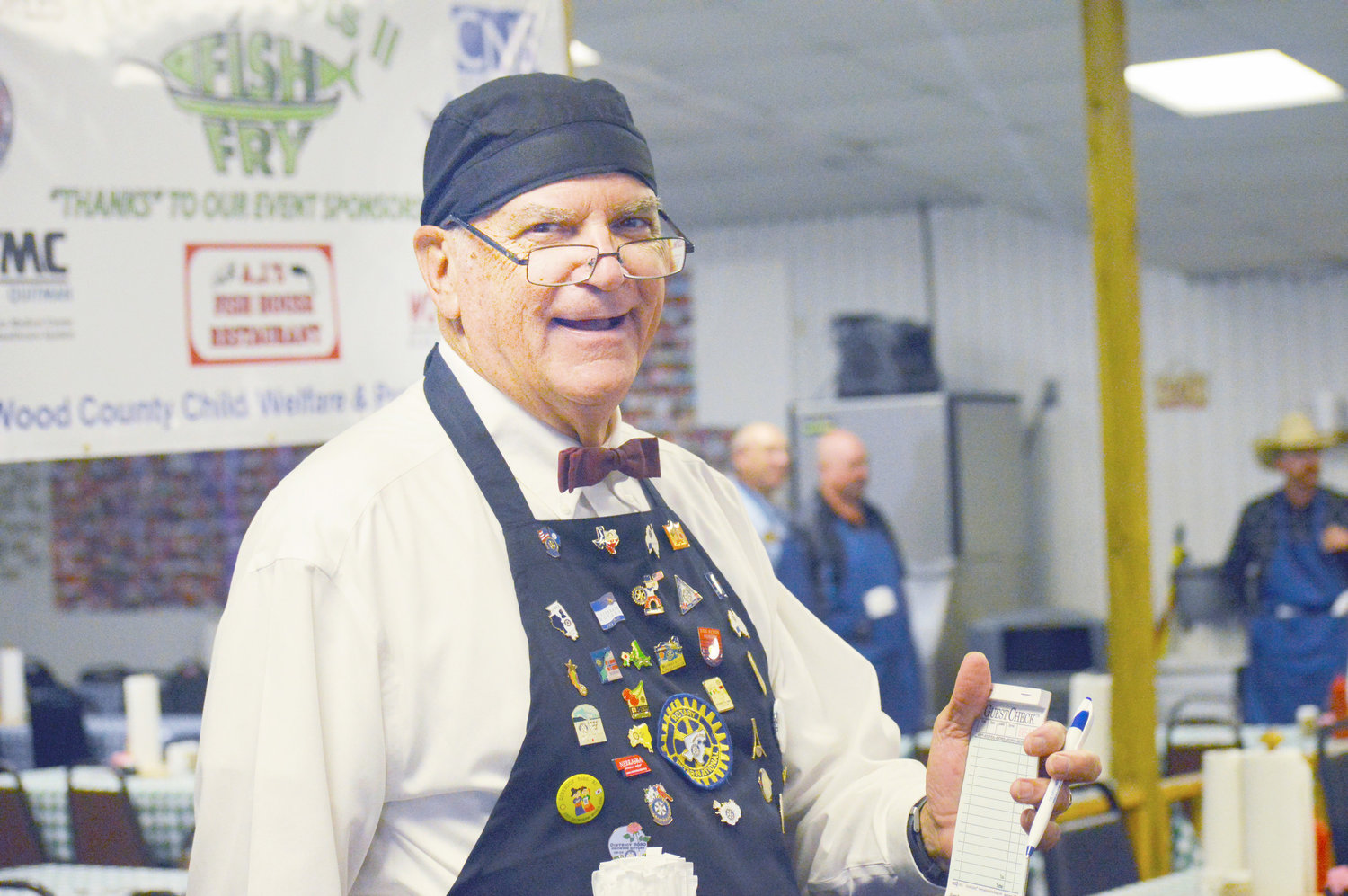 Retired Methodist Minister Bill Hedges was one of the waiters at Tips for Tots,
a fundraiser for Wood County foster children held at AJ’s Fish House at Lake Fork. In addition to waiter tips, funds were raised through sponsors, a live auction, raffle and bake sale. (Photo by Larry Tucker)
