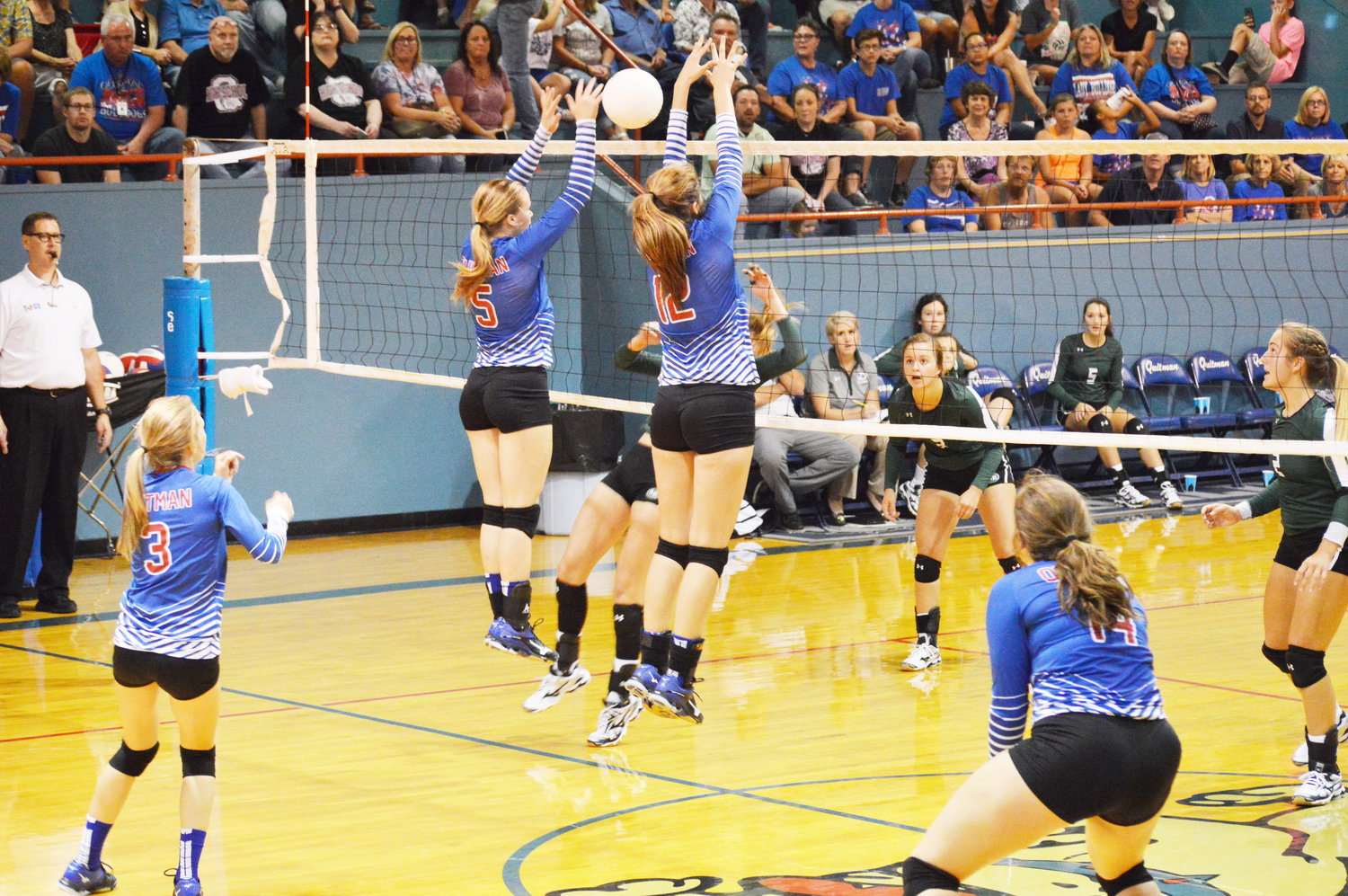 Madalyn Spears (5) and Kaci Raley (12) go up high at the net as Brittany Walls (3) and Cammie Hicks (14) prepare to back them up. (Monitor photo by Larry Tucker)