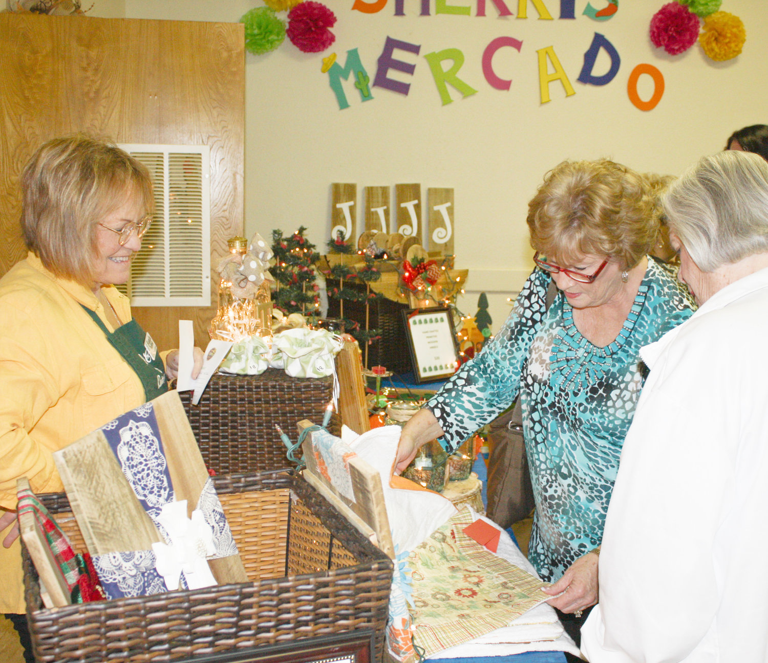 A couple of very interested shoppers take a close look at one of the offerings in Senora Sherri’s Mercado during the Quitman Pilot Club’s Fiesta Extravaganza Feliz Navidad.