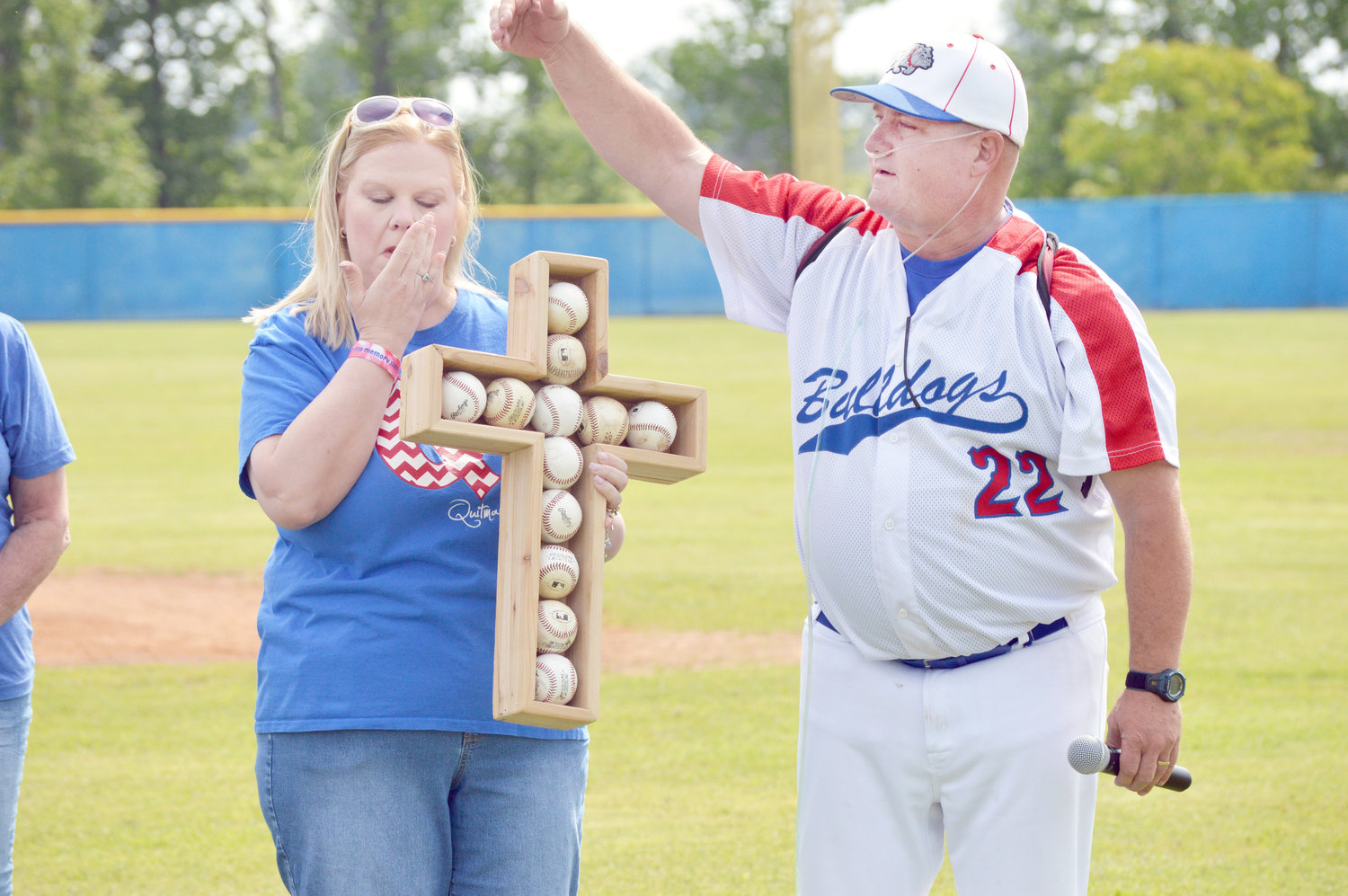 Quitman baseball coach Hayland Hardy presented a cross made of baseballs to Melissa Coats in honor of her son, the late Jacob Coats prior to last week’s Mineola game. (Monitor photo by Larry Tucker)