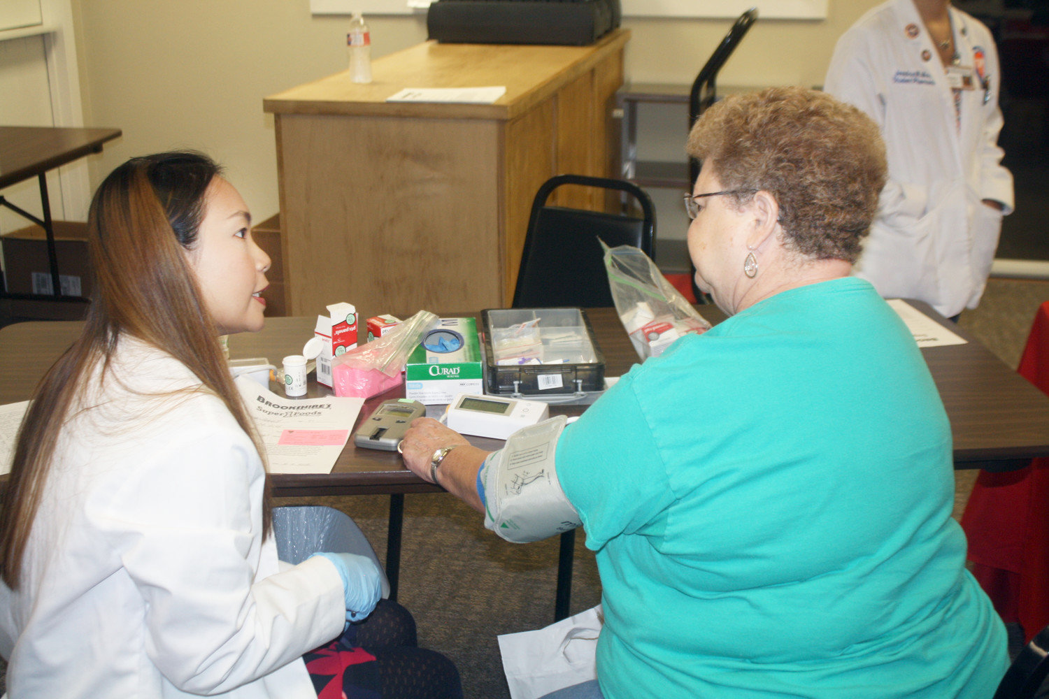 UT Tyler pharmacy student Joy Chaisri gives Daisy Bennett, Forever Young Activities Center treasurer, a blood pressure, blood sugar, cholesterol test by Brookshire’s at the Forever Young Activity Center community health fair for all ages on Oct. 4
