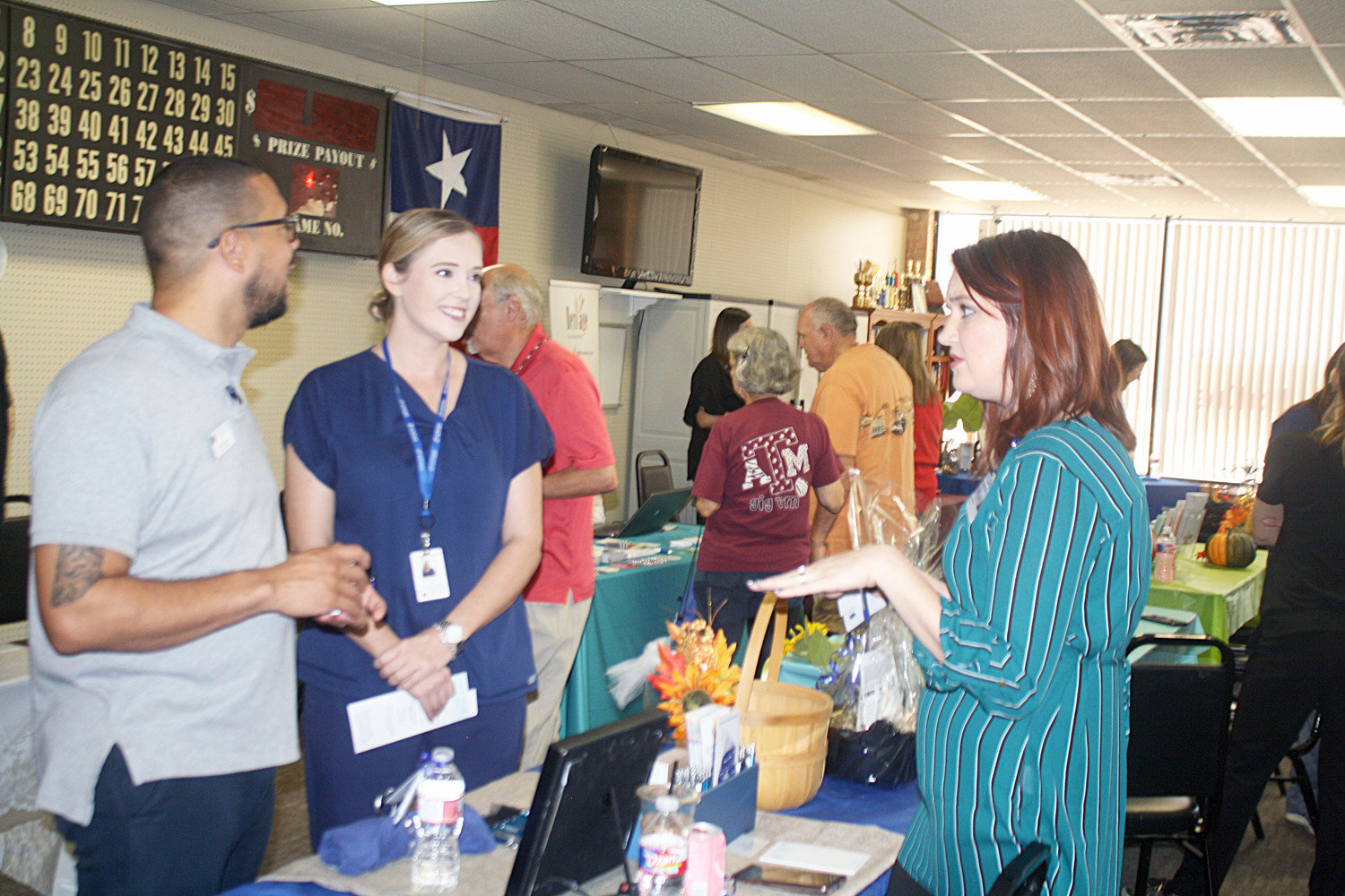 Katrina Davis of Reflections Hospice in Quitman speaks with Michael Howard and Angela Morris from Jordan Health at the Forever Young Activity Center community health fair for all ages on Oct. 4.
