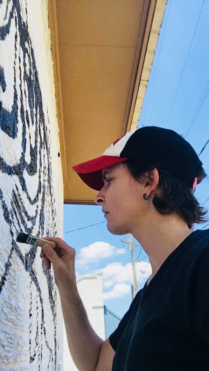 Wood County native artist Erika Fry works on her mural on the outside wall of the Robin’s Nest.