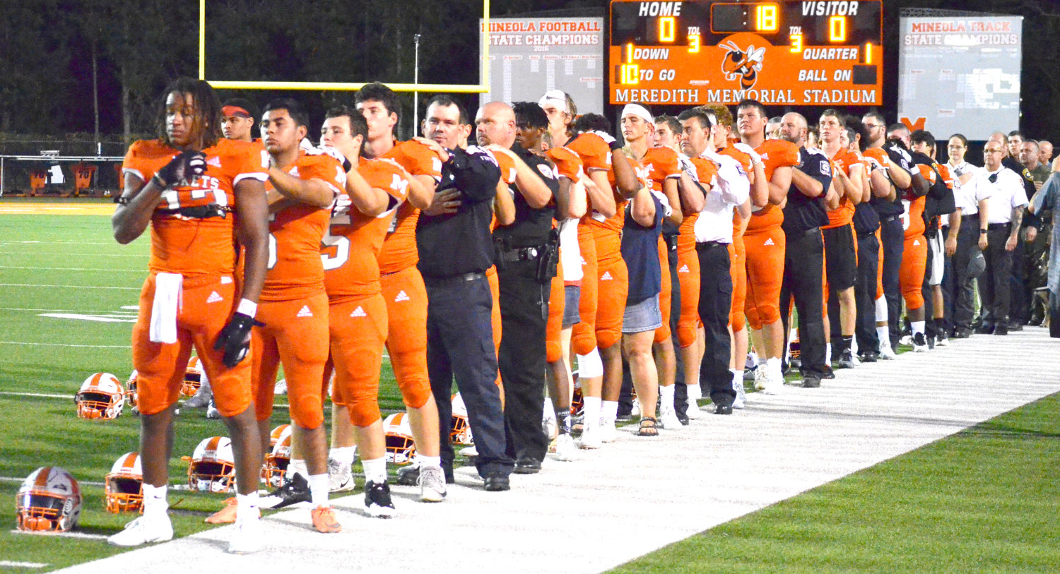First responders join Mineola football players for the playing of the “National Anthem”prior to Friday’s football game. The Mineola ISD honored first responders before the game and also during the halftime ceremonies.