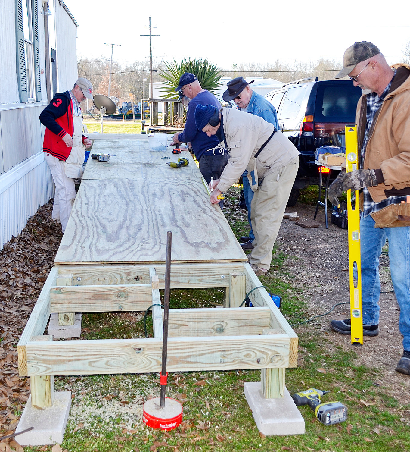 Members of the Broad Street Church of Christ in Mineola construct a wheelchair ramp for a Mineola resident last week. The team completed its 100th ramp this week in Yantis.