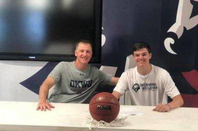 Quitman’s Jace Reid is pictured with Oklahoma Wesleyan University Head Coach Donnie Bostick as he signs to play college ball with the Eagles in Bartlesville, Okla.