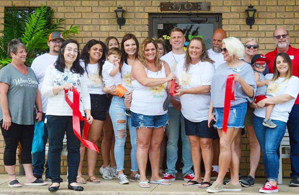Cutting the ribbon are Kellee Tarno (left) and Melissa Pollard (right) along with family, friends and Quitman chamber members.