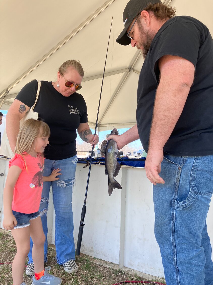 Sheila Jones and her granddaughter Paisley check out a catfish with Joshua Edwards.