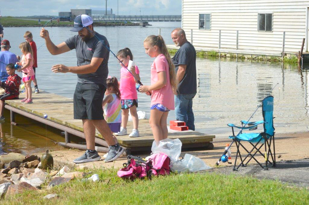 Kenny Nunez takes a look at the turtle caught by his daughter Emily at the Kid Fish Tournament at the Sabine River Authority headquarters at Lake Fork Saturday. In the background are Emily’s sisters, Madison and Aubrey.