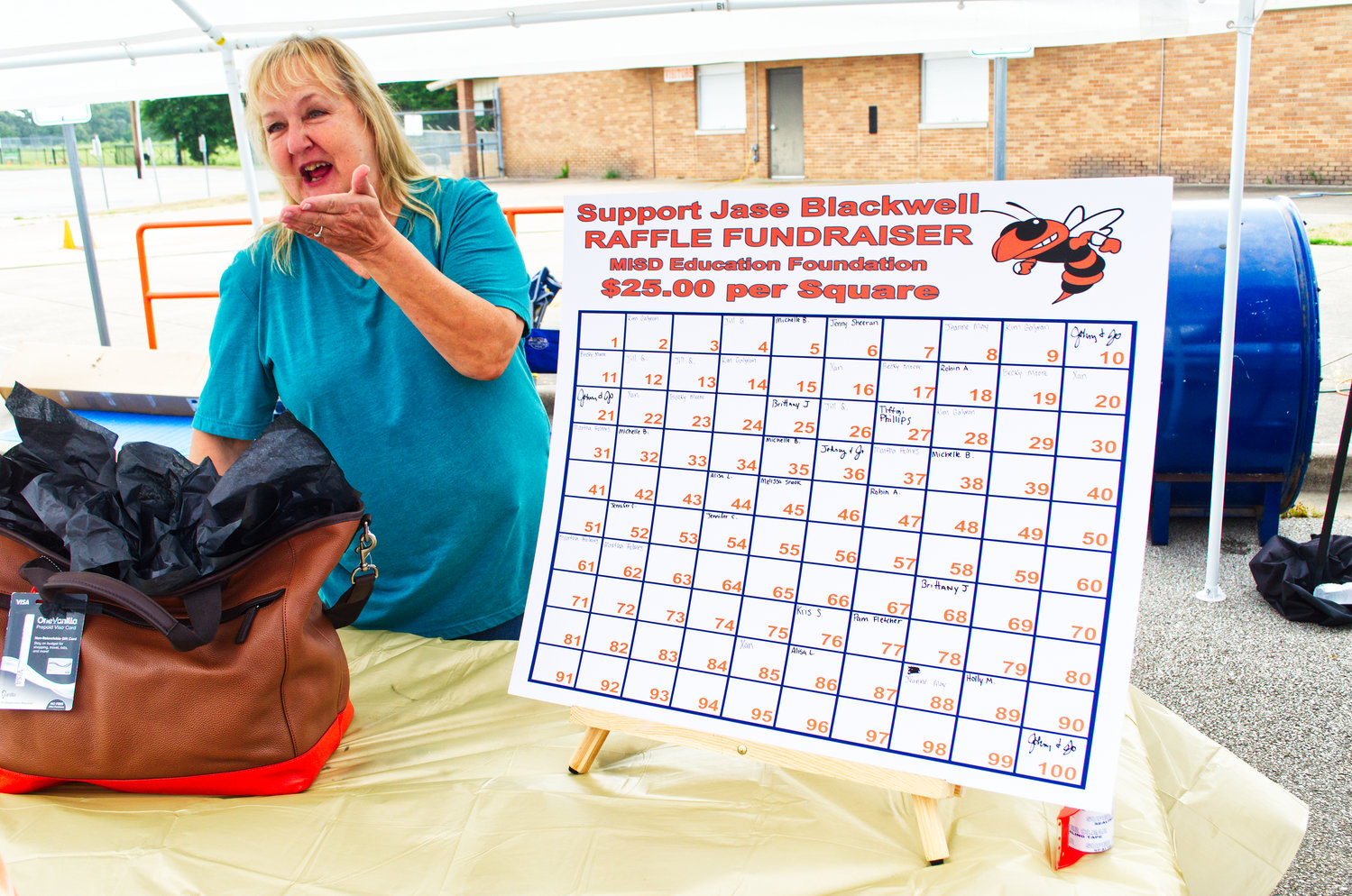 Martha Holmers with the Mineola ISD Foundation sells squares during a benefit for the Jase Blackwell family. (Monitor file photo)