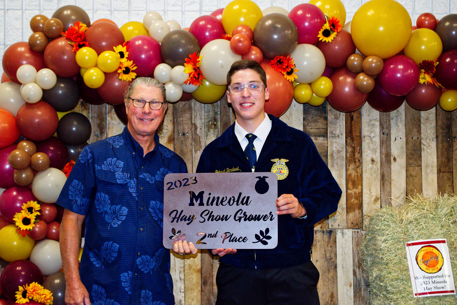 Gabriel Bardwell, Mineola FFA president, awards second-place hay grower Greg Walker with his plaque.